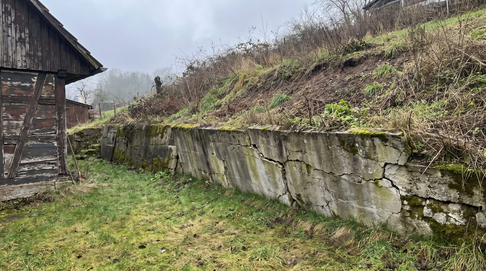 Hang mit alter bröckelnder Betonmauer